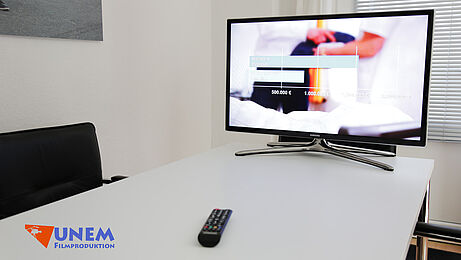Präsentationsraum mit Smart-TV und Fernbedienung zur Filmvorführung