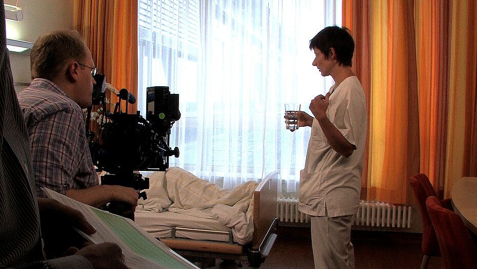 Der Regisseur gibt der Krankenschwester eine Regieanweisung zur aktuellen Szene.